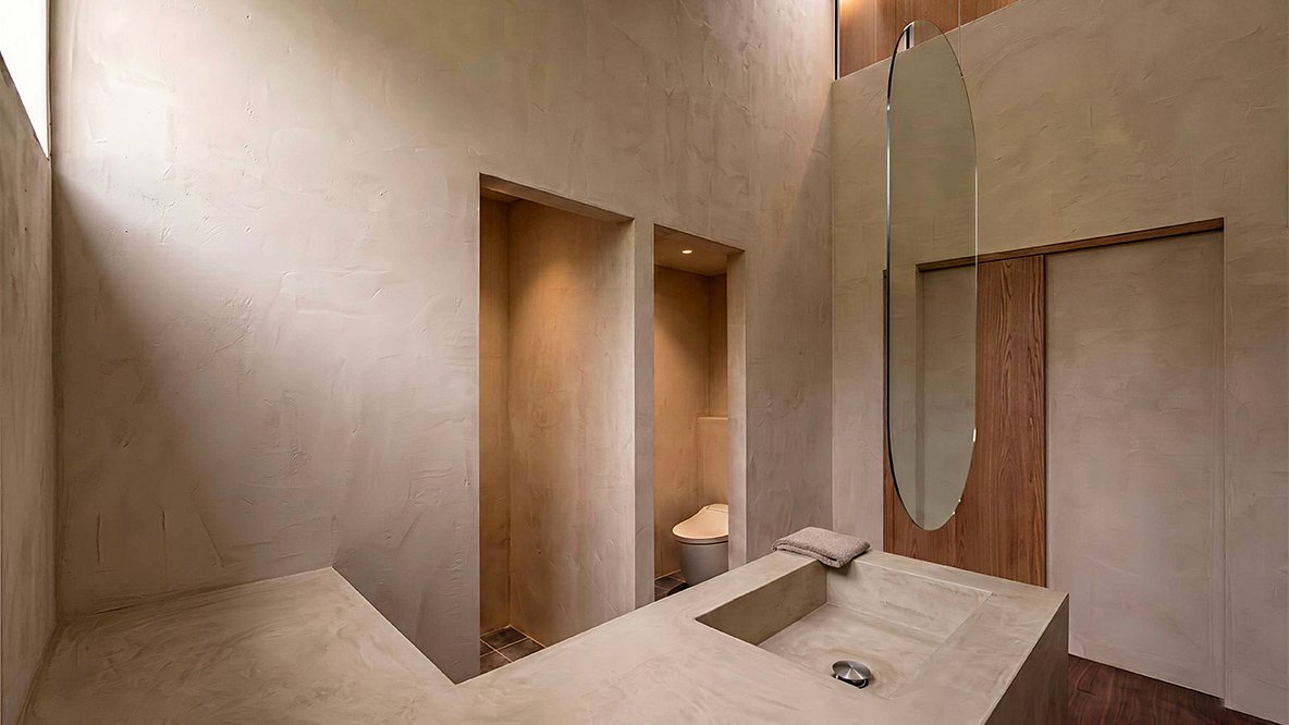 彫刻的な石の洗面台とフルレングスミラー、独立したトイレスペースのあるパウダールーム